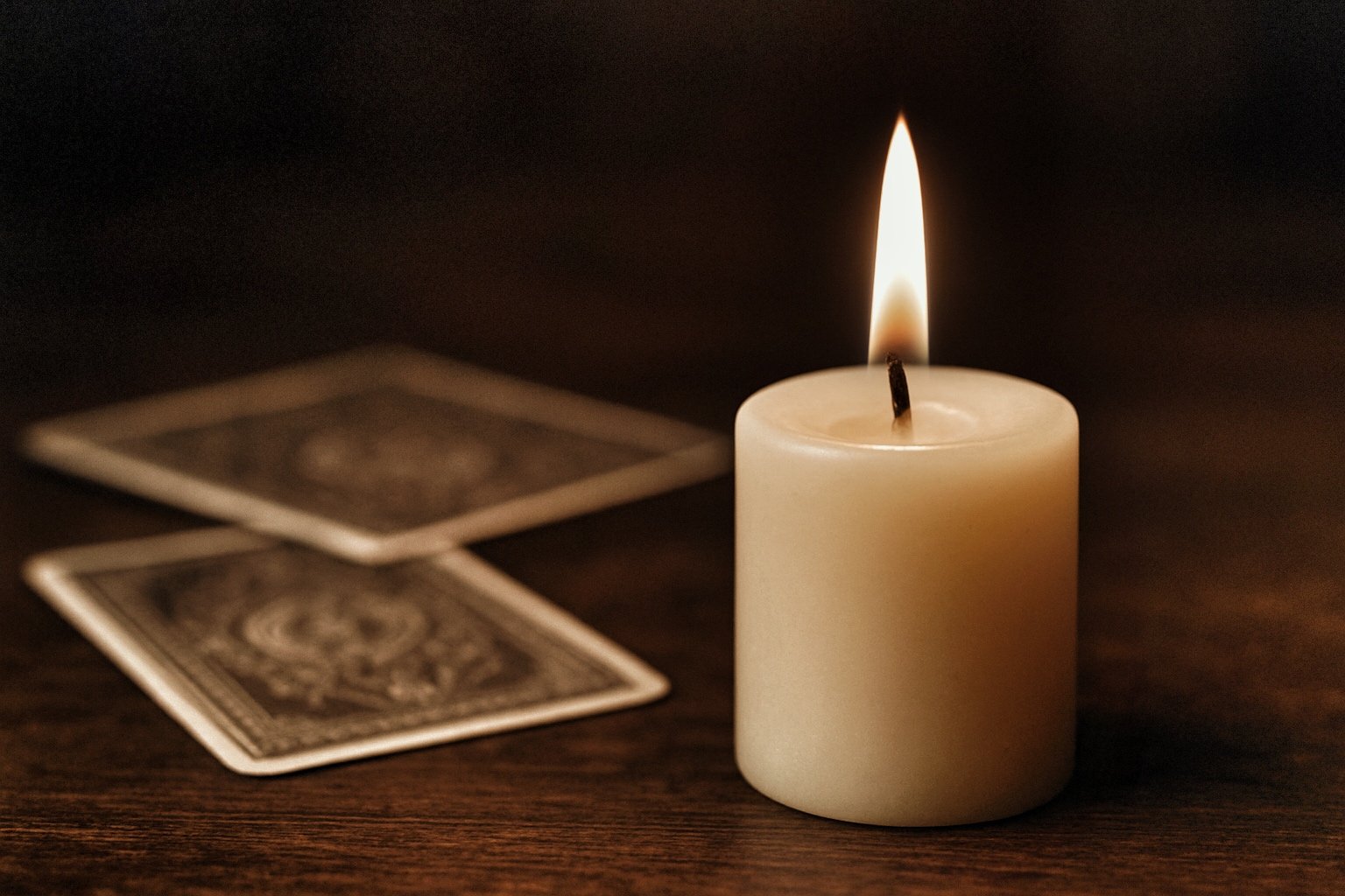 vela encendida con unas cartas de tarot sobre la mesa